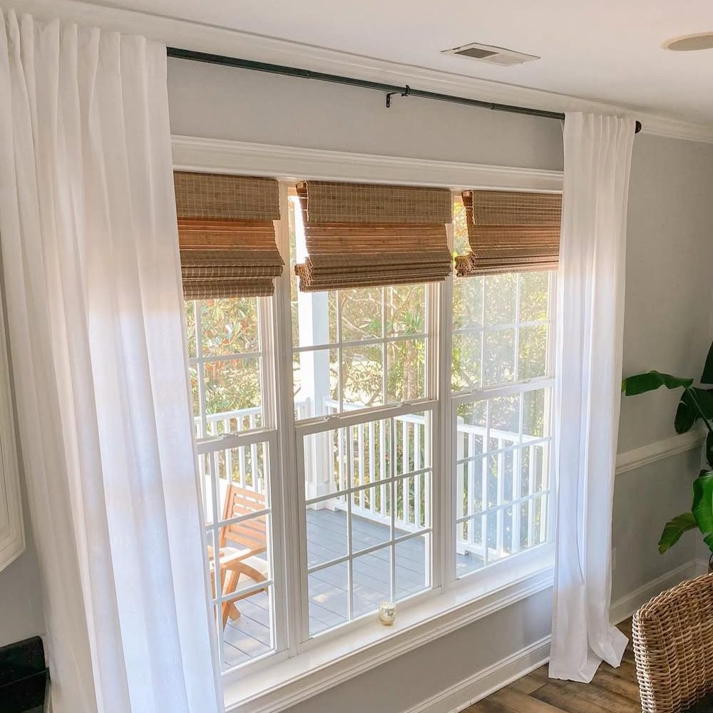 Close-up of bamboo roman shades in a fully raised position showing clean folds.