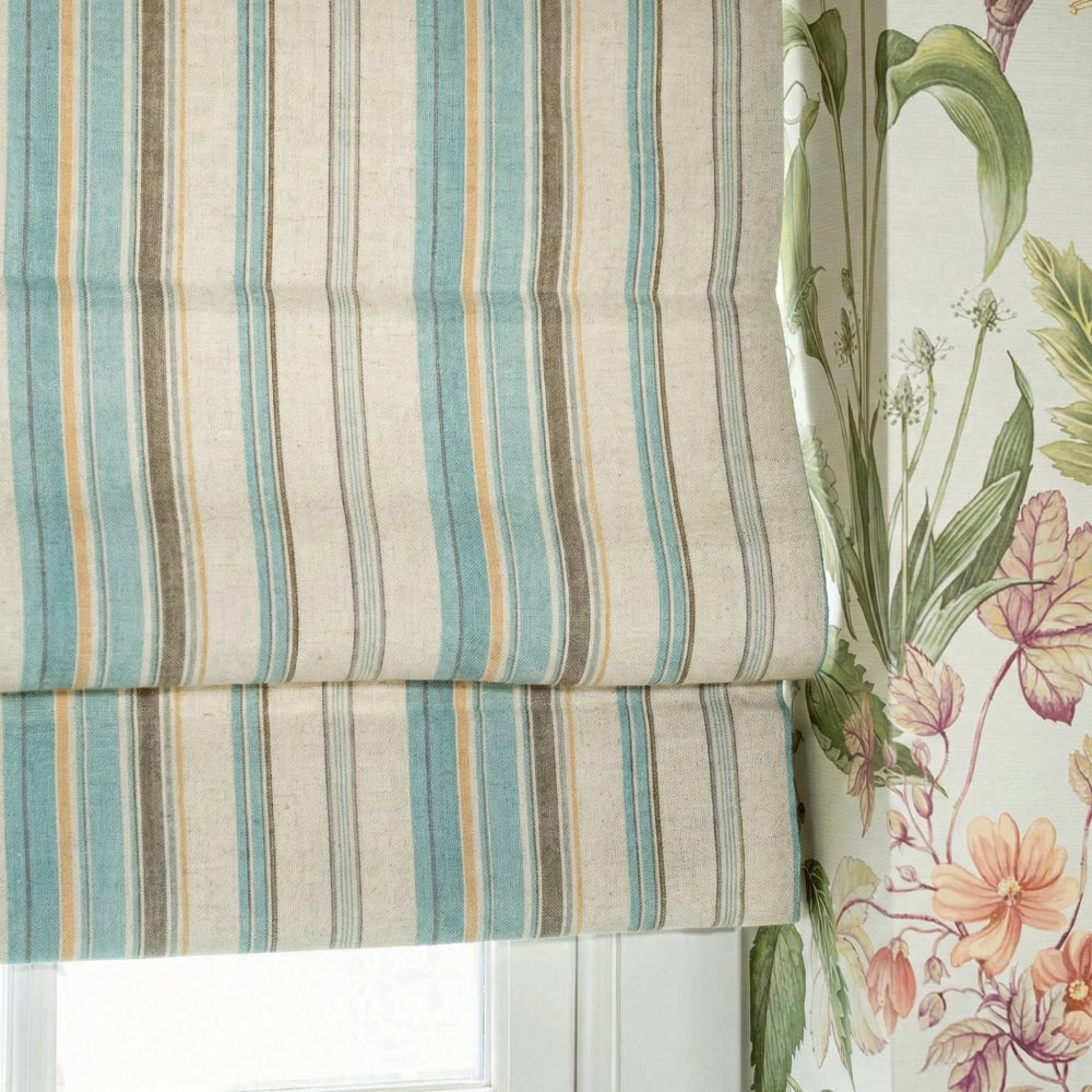 Close-up of custom striped linen roman shade in sage green and light blue, showing the vertical stripe pattern.