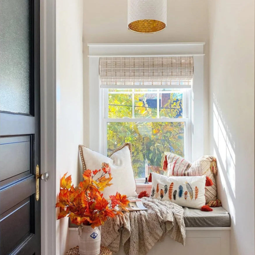 Minimalist white indoor bamboo shades with light filtering effect.