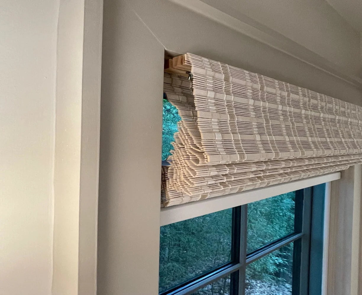 White bamboo shades in fully raised position for clean look.